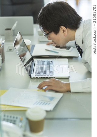 A businessman staring at the notebook computer 21592703