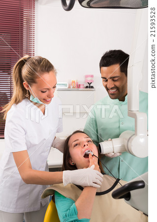 Dentist examines patient at clinic 21593528