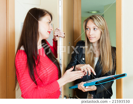 young female employee polling among people at home door young female employee polling among people at home door 21593530
