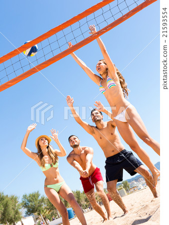 Cheerful pals playing beach volley 21593554