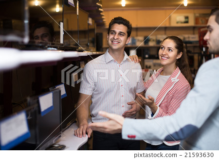 consultant helping young couple to choose PC monitor 21593630