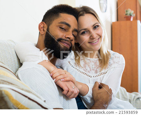 Young blonde and boyfriend cuddling on couch at home Young blonde and boyfriend cuddling on couch at home 21593859