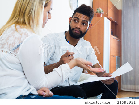 Interracial couple discussing banking offer for mortgage at home 21593931