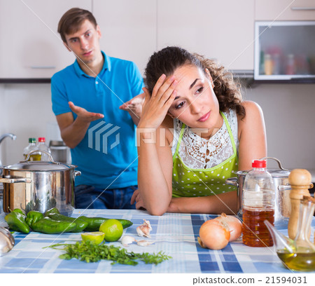 Upset man and frustrated woman at kitchen . 21594031