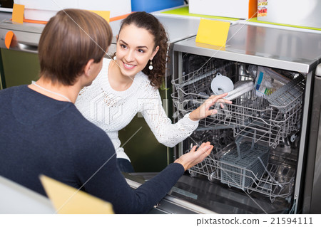 young couple choosing new dish washing machine in appliance sto young couple choosing new dish washing machine in appliance sto 21594111