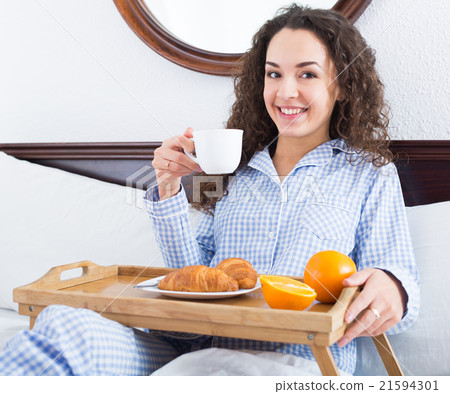 Smiling girl enjoying breakfast in bed 21594301