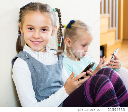 Girls playing online with phones 21594533