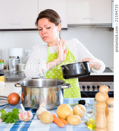 Woman with smelly pan in kitchen 21594735