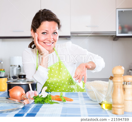Woman in apron sitting at table 21594789