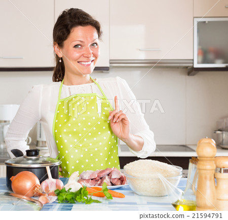 Woman cooking meat with rice and smiling 21594791