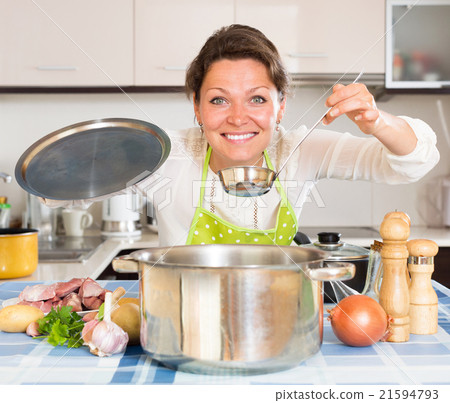 Happy housewife cooking meat and potatoes 21594793