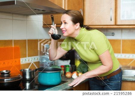 Housewife preparing meal in kitchen Housewife preparing meal in kitchen 21595286