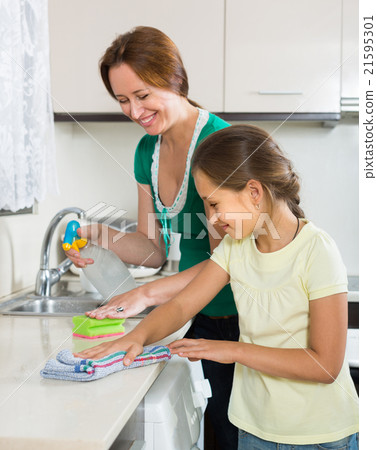 Little girl helping mother at kitchen 21595301