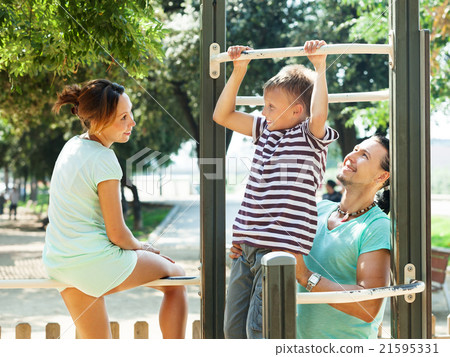 Happy parents with son training on pull-up bar 21595331
