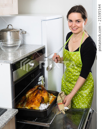 Woman cooking capon in baking tray. Woman cooking capon in baking tray. 21595544