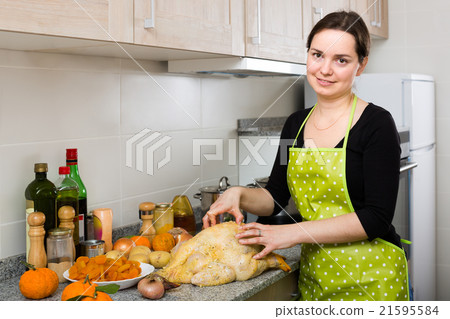 Woman preparing capon indoors . Woman preparing capon indoors . 21595584