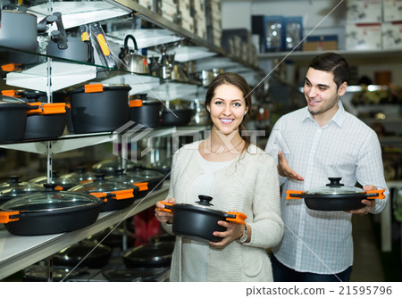 couple chooses pans in shop cookware 21595796