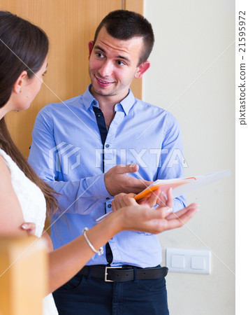 woman and man standing with official papers near door 21595972