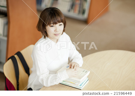 讀一本書的婦女在圖書館裡 21596449