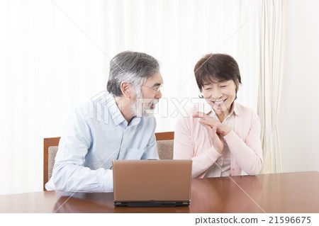 Senior couple discussing while playing PCs Internet shopping Internet mail order 21596675