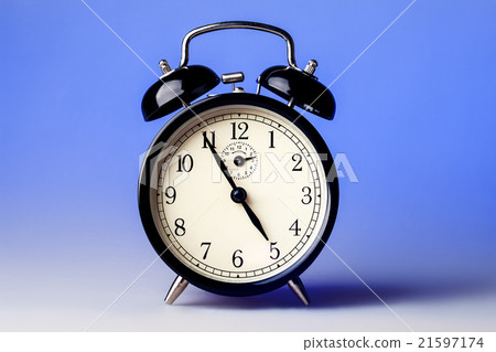 Black old fashioned alarm clock on blue background Black old fashioned alarm clock on blue background 21597174