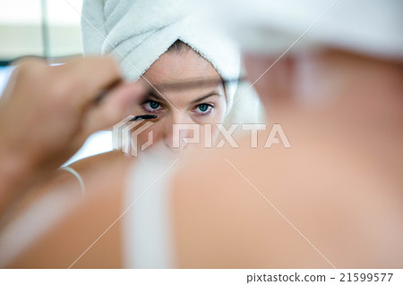 woman applying mascara in the mirror woman applying mascara in the mirror 21599577