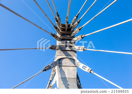 Modern cable bridge pylon against blue sky 21599935