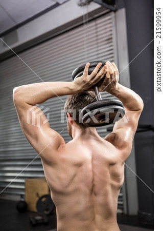 Rear view of shirtless man lifting heavy dumbbell Rear view of shirtless man lifting heavy dumbbell 21599954