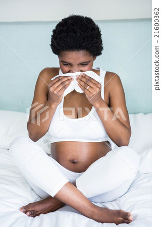 Pregnant woman blowing her nose Pregnant woman blowing her nose 21600362