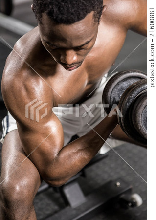 Shirtless man lifting dumbbell on bench 21600881