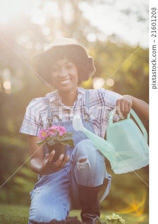Smiling woman crouching in the garden 21601208
