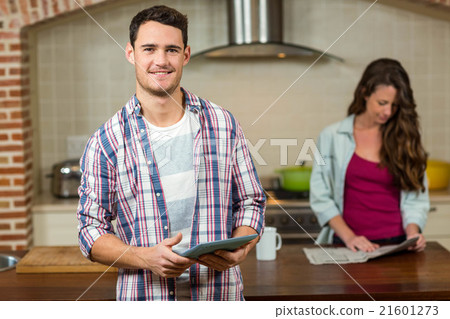 Man using tablet in kitchen Man using tablet in kitchen 21601273