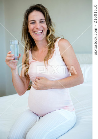 smiling pregnant woman drinking water 21601510