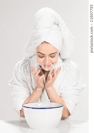Young woman washing face with clean water Young woman washing face with clean water 21607785