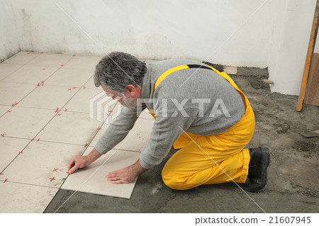Home renovation, worker placing tile 21607945