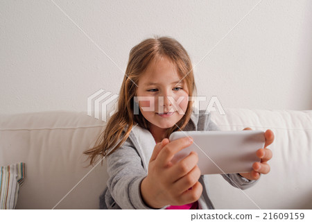 Girl at home sitting on sofa, taking selfie Girl at home sitting on sofa, taking selfie 21609159