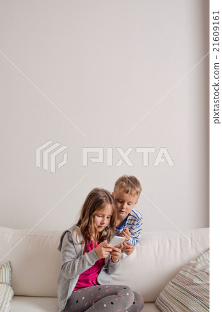 Children at home sitting on sofa, playing with Children at home sitting on sofa, playing with 21609161