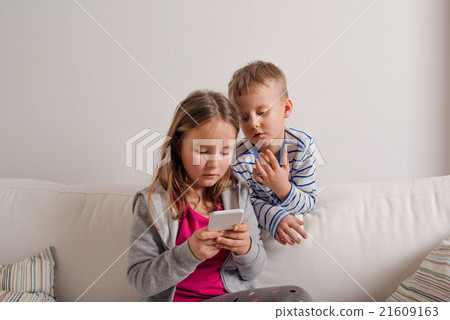Children at home sitting on sofa, playing with Children at home sitting on sofa, playing with 21609163