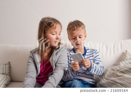 Children at home sitting on sofa, playing with Children at home sitting on sofa, playing with 21609164