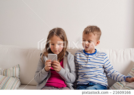 Children at home sitting on sofa, playing with Children at home sitting on sofa, playing with 21609166