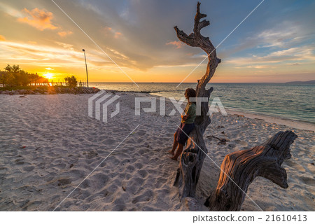 Woman on the beach at sunset Woman on the beach at sunset 21610413