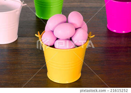 Violet easter eggs in a yellow bucket 21615252