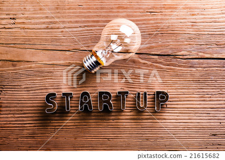 Office desk with start up sign and light bulb. 21615682