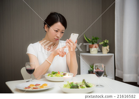 A lady while eating 21616582
