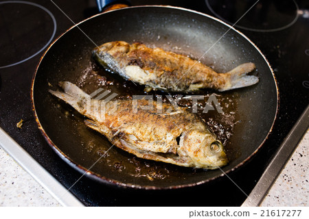 Fried fish in a frying pan on the cooker 21617277