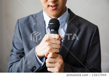 Young man holding microphone without confidence Young man holding microphone without confidence 21617444