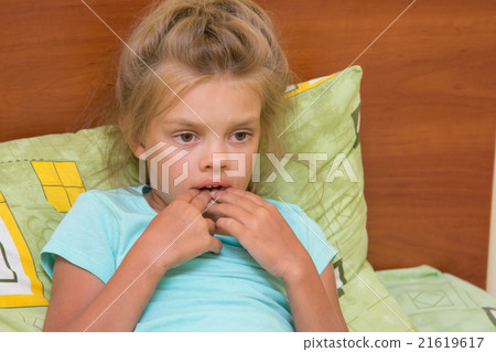 Six-year girl looks thoughtfully at one point and keeps finger in mouth Six-year girl looks thoughtfully at one point and keeps finger in mouth 21619617