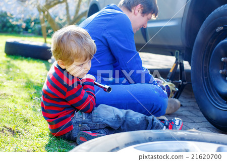 Little kid boy and his father changing wheel on Little kid boy and his father changing wheel on 21620700