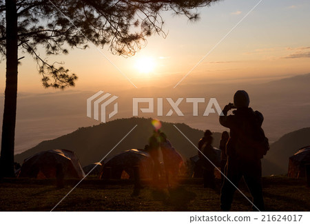 Campers taking picture of sunrise with smart phone 21624017