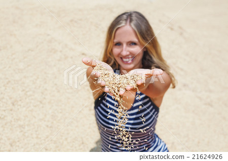 Woman with handful of raw rice grains in hands Woman with handful of raw rice grains in hands 21624926